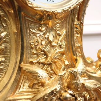 a large and ornate French gilt brass antique mantel clock in the Louis XV style with doves and floral leaf design. The eight day movement is by Japy Freres and strikes on a bell