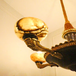 An Art Deco period bronze chandelier in the Empire Style with gilt bronze arms terminating to alabaster shades