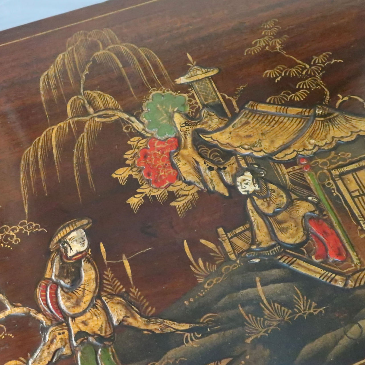 Chinese chinoiserie design of a pagoda and two men painted on an antique mahogany table