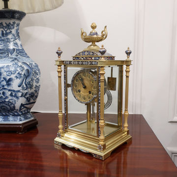 An antique Victorian French brass four glass mantel clock with beautifully chased slender fluted columns and decorative champleve blue coloured enamel ornamentation to the case and dial. The clock has an eight day movement which strikes the hours and half hours on a gong