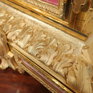 A French decorative bronze gilt antique mantel clock with porcelain panels. The eight day movement by Japy Freres strikes the hours on a bell