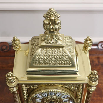 an antique French Victorian brass mantel clock with decorative case and eight day movement by A.D Mougin striking the hours on a bell