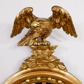 A Regency giltwood antique wall mirror with caved eagle and convex mirror plate