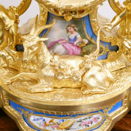 French mid 19th century gilt bronze antique mantel clock in the Louis XV style with porcelain panels. The movement strikes on a bell and is by Henry Marc of Paris