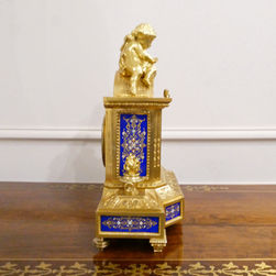 A French gilt bronze 19th century antique mantel clock with cherubs to the top and royal blue porcelain panels. The movements strikes on a bell.