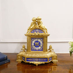 A French gilt bronze 19th century antique mantel clock with cherubs to the top and royal blue porcelain panels. The movements strikes on a bell.