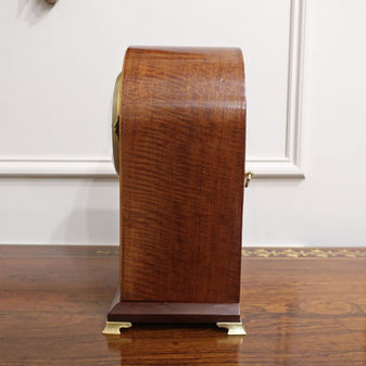an antique Edwardian French small mantel clock with mahogany case and shell inlay to the front of the case with white enamel dial and movement striking on a gong