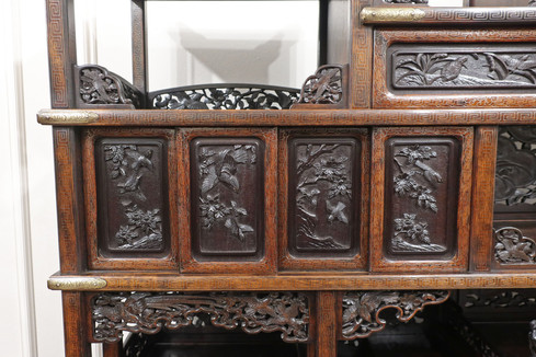an antique Japanese Meiji Period shodana display cabinet with silver inlay and carving of landscapes, birds and flowers. There are sliding doors, staggered shelving and drawers