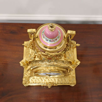 A French decorative bronze gilt antique mantel clock with porcelain panels. The eight day movement by Japy Freres strikes the hours on a bell