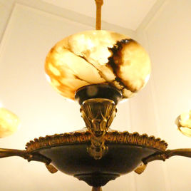 An Art Deco period bronze chandelier in the Empire Style with gilt bronze arms terminating to alabaster shades
