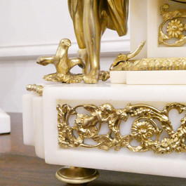 French Louis XVI style antique mantel clock with gilt bronze female and cherub figures with doves, on a white marble base with movement striking on a bell