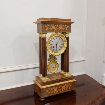 Antique French 19th century rosewood portico mantel clock with floral satinwood marquetry inlay and Corinthian columns, finished with brass gilt capitals and eight day duration movement striking on a bell
