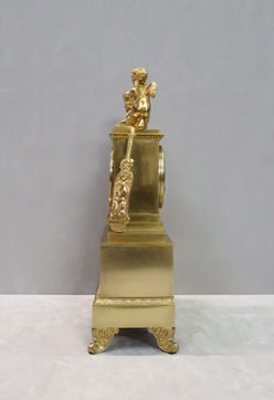 Antique French Victorian bronze gilt Romanesque Empire style mantel clock adorned by the goddess Diana wearing a draped gown holding a quiver under her arm and a putti playing a lyre