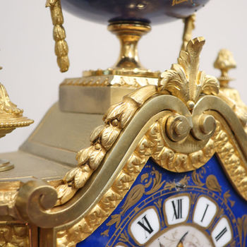an antique French Victorian bronze gilt ormolu mantel clock with blue porcelain panels and domes sides hand painted with musical instruments and butterflies. The movement strikes on a bell by Japy Freres