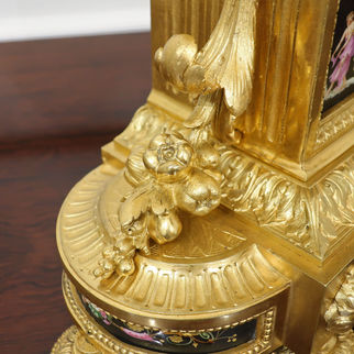 French 19th century gilt bronze antique mantel clock in the Louis XVI style with black hand painted porcelain panels and movement striking on a bell