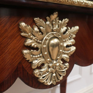 A French antique side table in the Louis XV style with gilt bronze ormolu mounts standing on slender square tapered cabriole legs