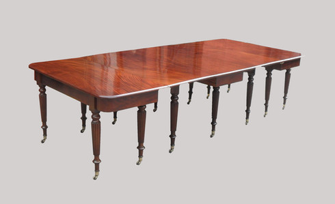 an antique Georgian mahogany extending dining table seating 10 people standing on turned reeded legs attributed to Gillows of Lancaster & London