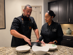 Chef Al Barboza and his wife, Zee, working together in the kitchen, preparing tableware for a private dining experience.