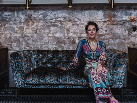 Woman sitting on patterned sofa in patterned clothing