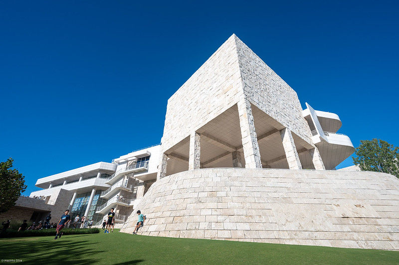 Green lawn in the foreground abut a limestone building in the background with modernist design by Richard Meier.