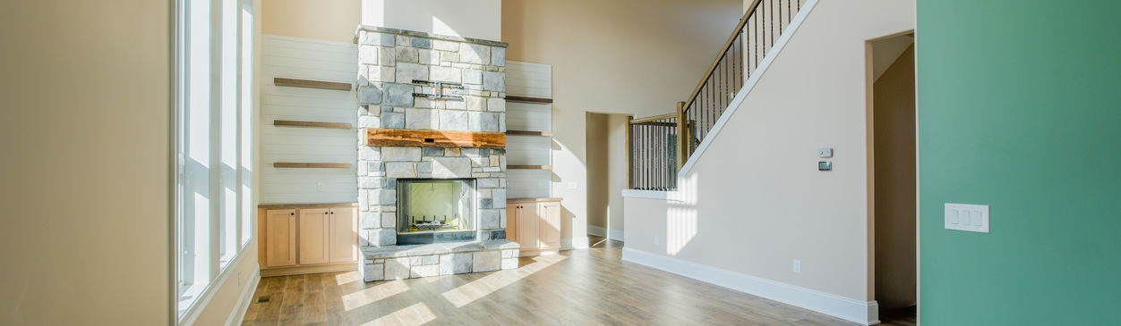 Living room with a fireplace and staircase.