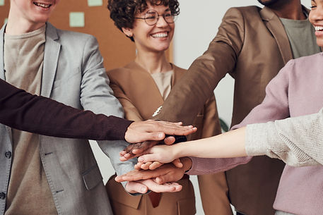 A group of people putting their hands together in a circle.