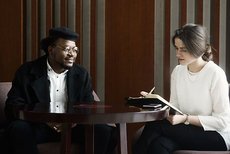 A man and woman sitting at a table talking to each other.
