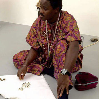 Baba Sangosakin performs divination with cowries.