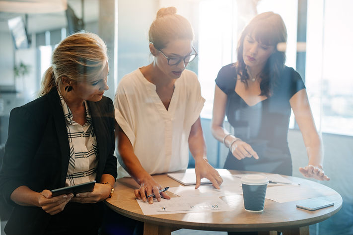 Three people discussing over paperwork