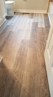 Bathroom with wood-look flooring, showcasing durable flooring material types and design.