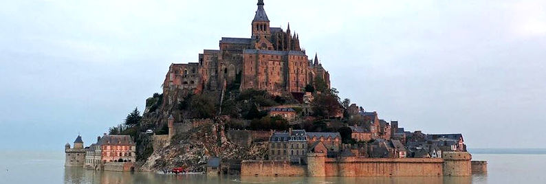 Cette photographie met en valeur la majesté du Mont Saint-Michel, véritable trésor du patrimoine architectural français. Perché sur son îlot rocheux et entouré d'une baie aux paysages changeants, ce chef-d'œuvre d'art et de culture attire chaque année des milliers de visiteurs du monde entier. Au premier plan, les remparts et les tours de l'abbaye bénédictine témoignent de l'histoire et de la richesse culturelle de ce site emblématique. Les étroites ruelles pavées et les maisons à colombages, nichées au pied de l'abbaye, invitent à la découverte et à la flânerie. Au loin, la baie du Mont Saint-Michel, théâtre des plus grandes marées d'Europe, offre un spectacle naturel saisissant, sublimant ainsi la beauté de ce patrimoine architectural d'exception. Cette image illustre la préservation et la mise en valeur de notre héritage artistique et culturel, incarné par ce site unique, inscrit au patrimoine mondial de l'UNESCO.