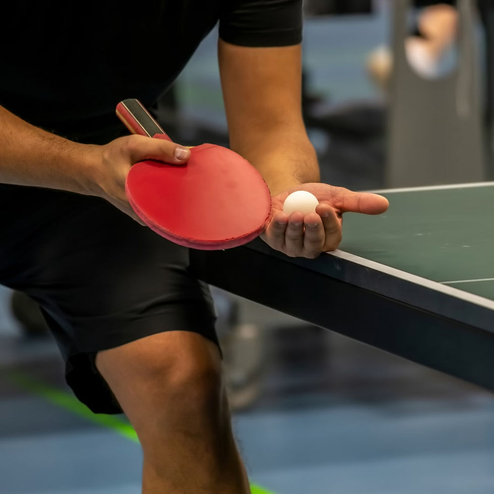 Mann hält Tischtennisschläger und Tischtennisball in der Hand, repräsentiert Indoor-Tischtennis in München
