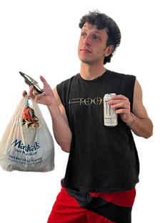 Elvis holding a Monster energy can and a Marshall's bag as he stands inquisitively.