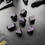 Thumbnail: Set of black dice with purple numbers, Roll Gothica on a black surface.