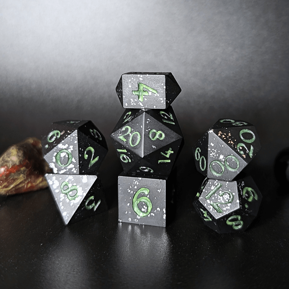 Black dice set with metallic silver foil and glow in the dark green numbers made with Jesmonite, on a dark background