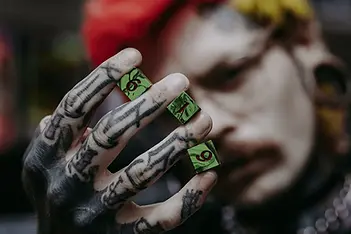 Person holding up dice with the number six, Roll Gothica handmade dice.