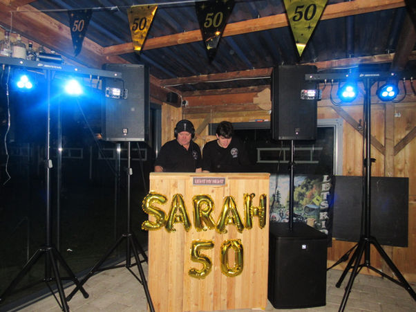 Lightmynight medewerker bij een compleet opgestelde licht- en geluidsset.