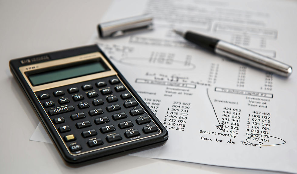 Calculator, pen, and paper with financial data and handwritten notes. Focus on calculations and planning. Office setting.