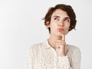 A thoughtful person in a patterned shirt rests a finger on their chin against a white background, appearing to ponder or contemplate.