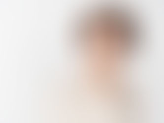 A thoughtful person in a patterned shirt rests a finger on their chin against a white background, appearing to ponder or contemplate.