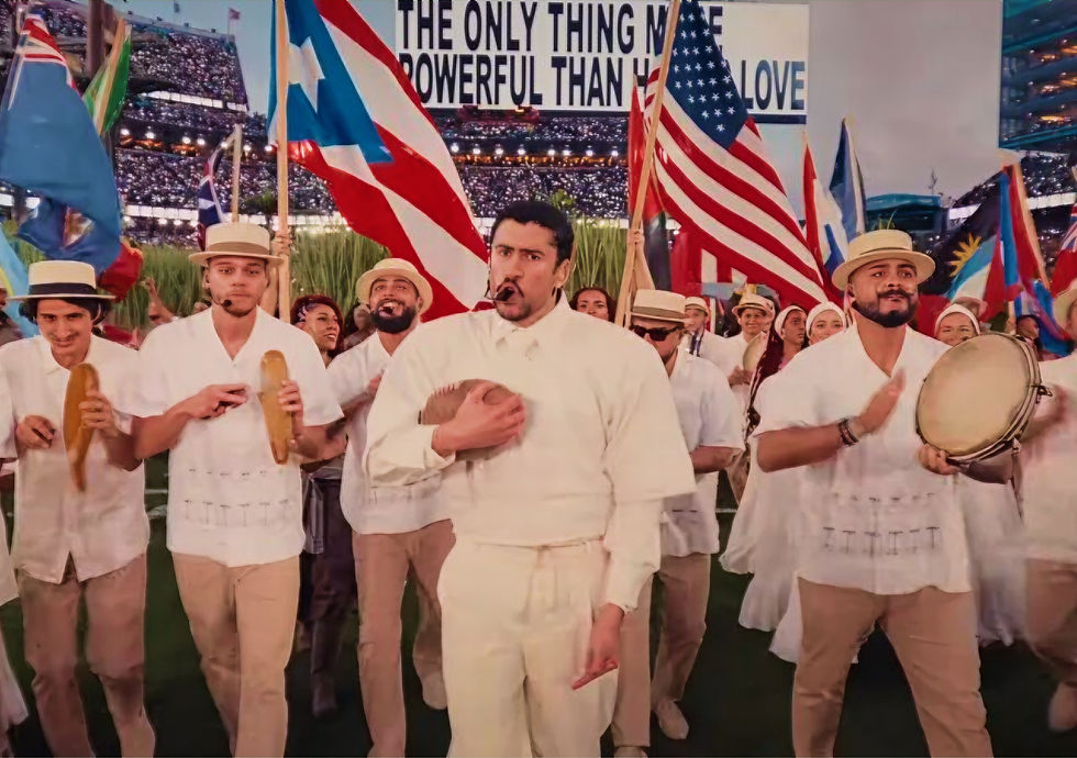 Musicians and performers dressed in white carrying flags during a cultural presentation at a stadium event. Celebration of identity, community and visual storytelling through live entertainment and performance design.