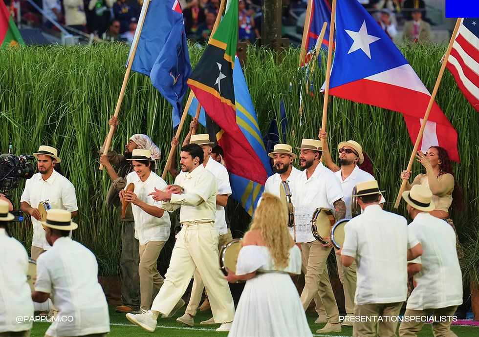 Musicians and performers dressed in white carrying flags during a cultural presentation at a stadium event. Celebration of identity, community and visual storytelling through live entertainment and performance design.