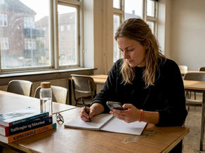 En elev sidder for sig selv og læser i teorilokalet på køreskolen.