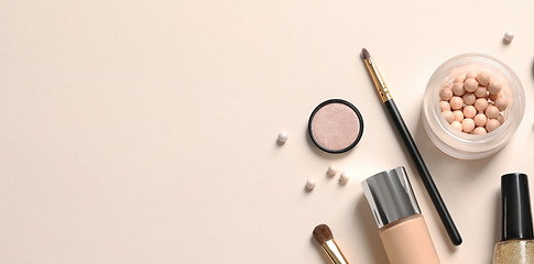 Cosmetic bag and different luxury makeup products on color background