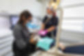 Femme dentiste et jeune assistante réparant la dent d'un patient.