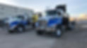 Two blue crane and transportation trucks on the road