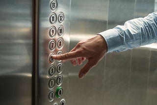 Finger pressing the button in the elevator
