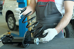 A car service specialist checks the compatibility of the spring part and the shock absorbe
