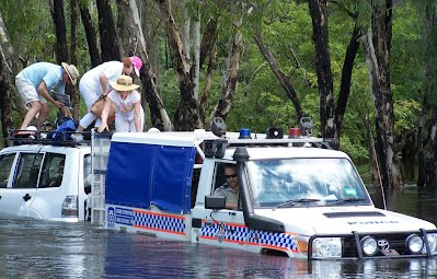 Police rescue the passengers from a vehicle disabled while crossing Magela Creek in flood.