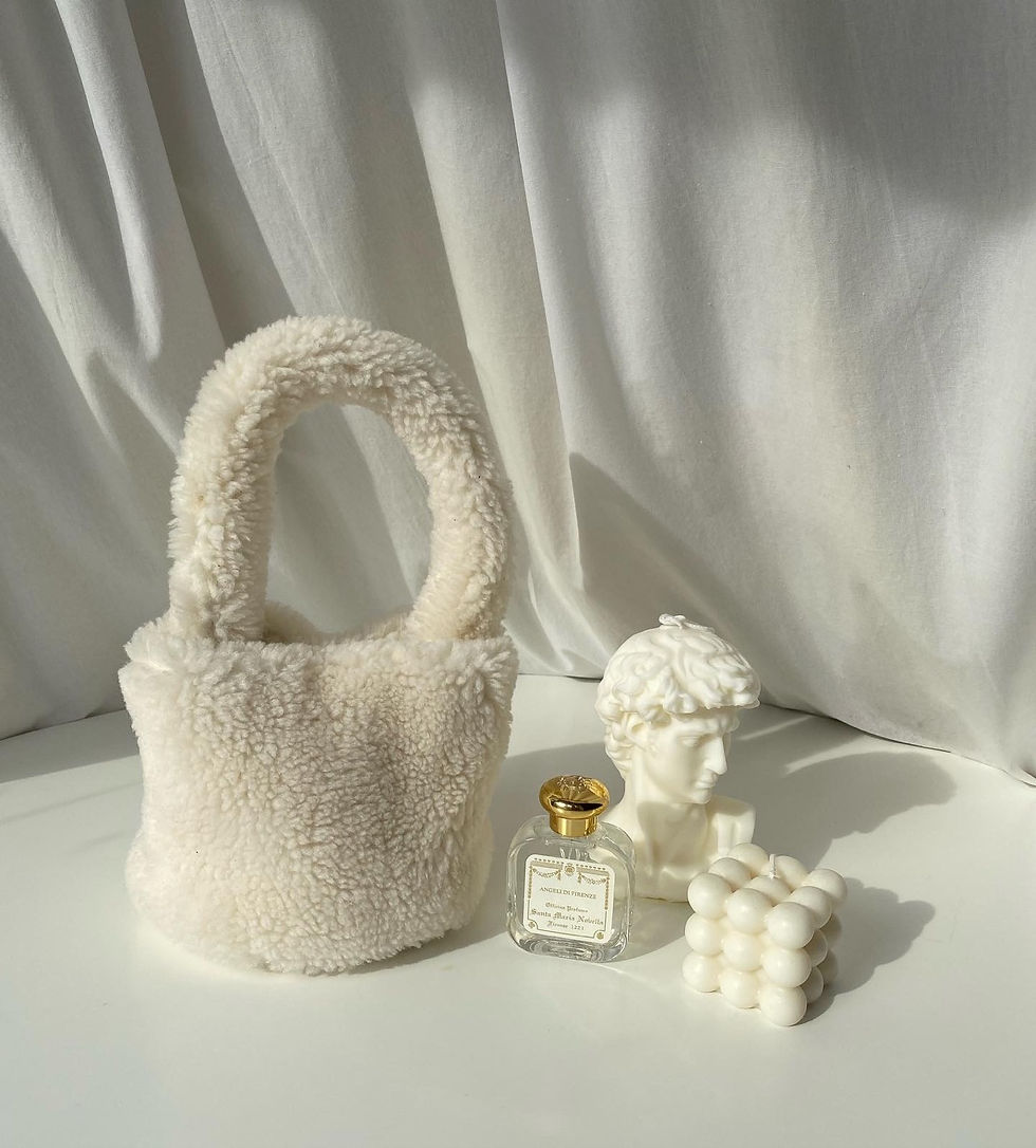 Thumbnail: White Eco Shearling mini bag, a perfume, a white bust, and a cube scuplture